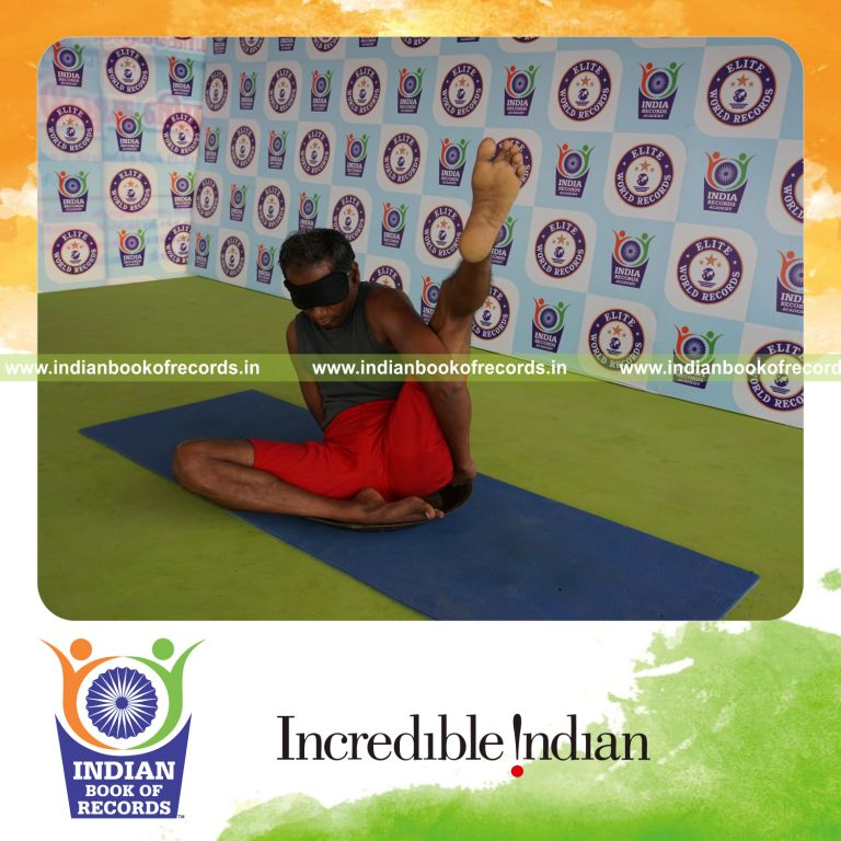 individual holding vama ardha parsva krounchasana yoga pose blindfolded on a brass plate for record in Indian Book of Records