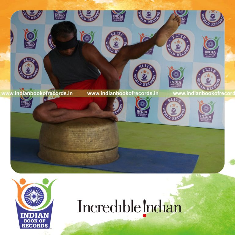individual holding vama ardha parsva krounchasana yoga pose blindfolded on a vessel for record in Indian Book of Records
