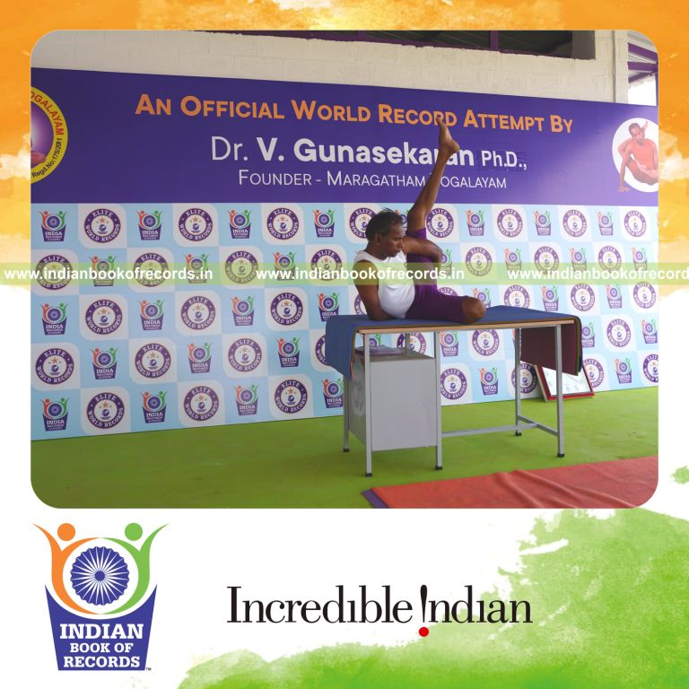 individual holding vama ardha parsva krounchasana yoga pose on a table for record in Indian Book of Records