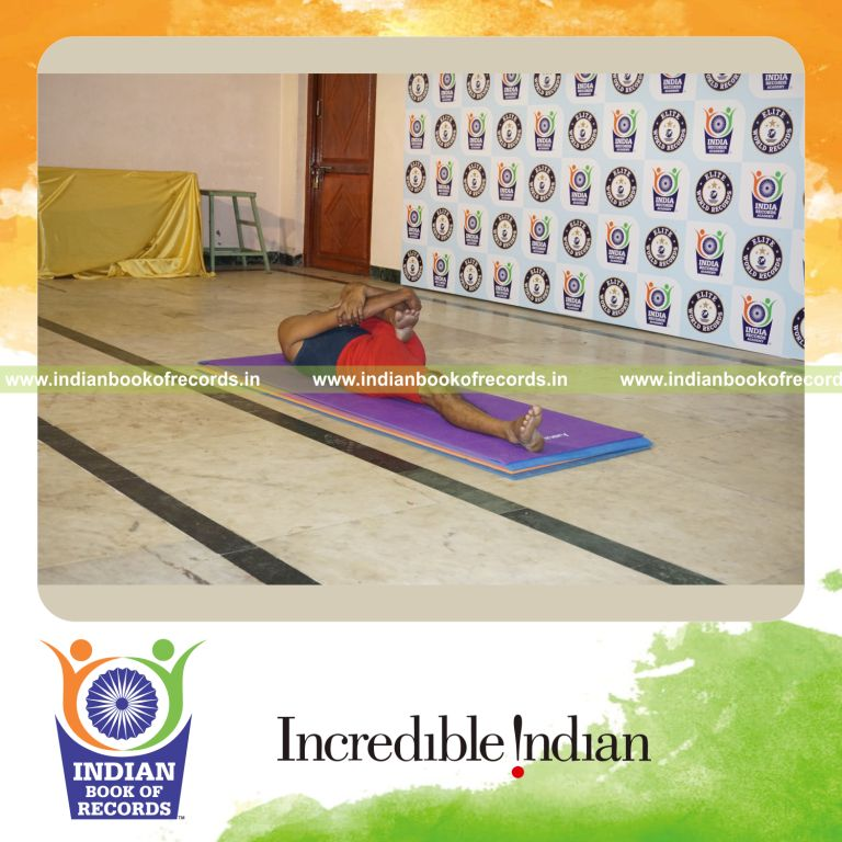 individual holding vama ardha pavanamuktasana yoga pose for record in Indian Book of Records