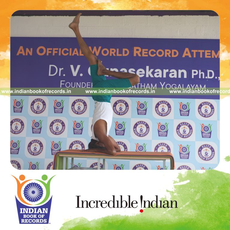 an individual holding vama ardha salamba sirsasana yoga pose blindfolded on a table continuously for the longest duration with stability and control for a record in Indian Book of Records