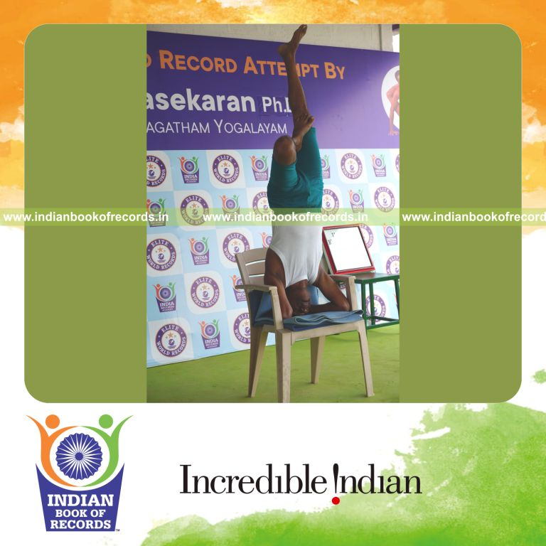 individual holding vama ardha sirsasana yoga pose on a chair for record in Indian Book of Records