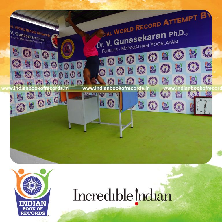 individual holding vama ardha sirsasana yoga pose on a table for record in Indian Book of Records