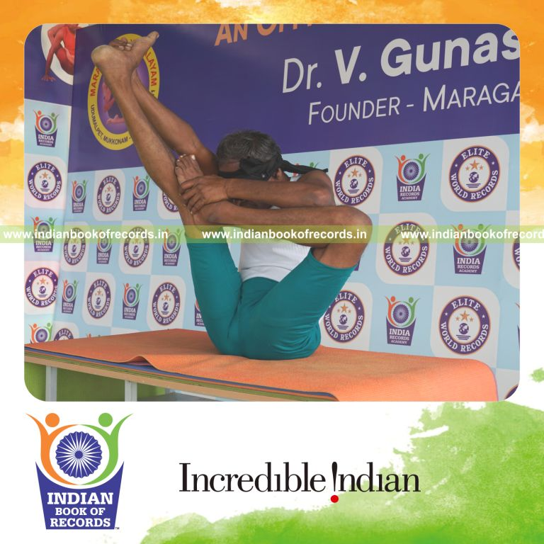an individual holding vama ardha urdhva mukha paschimottanasana yoga pose blindfolded on a table continuously for the longest duration with balance and control for a record in Indian Book of Records