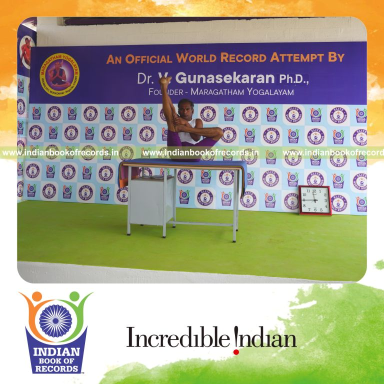 individual holding vama ardha urdhva mukha paschimottanasana yoga pose on a table for record in Indian Book of Records