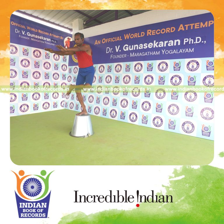 individual holding vama ardha utkatasana yoga pose on a bucket for record in Indian Book of Records