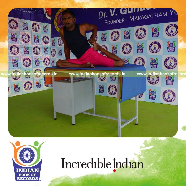 individual holding vama ardha vamadevasana yoga pose on a table for record in Indian Book of Records