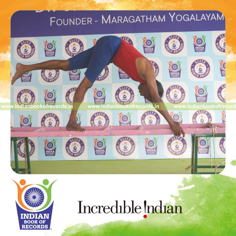 individual holding vama ekapada adho mukha svanasana yoga pose on a ladder for record in Indian Book of Records