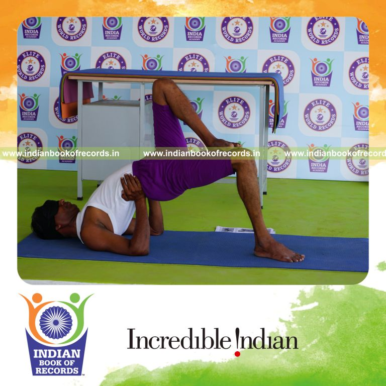individual holding vama ekapada janu setu bandha sarvangasana yoga pose blindfolded for record in Indian Book of Records
