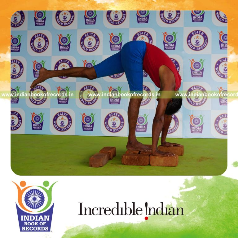 individual holding vama ekapada padahastasana yoga pose on bricks for record in Indian Book of Records