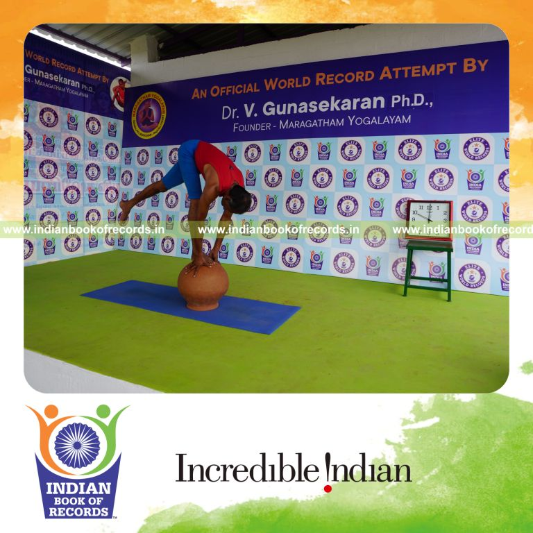 individual holding vama ekapada padahastasana yoga pose on a pot for record in Indian Book of Records