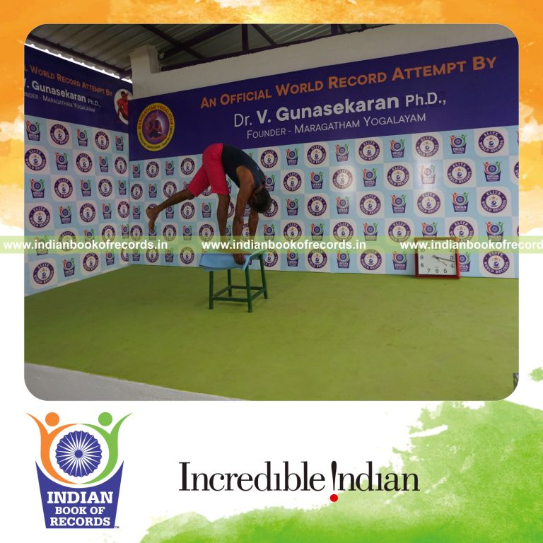 individual holding vama ekapada padahastasana yoga pose on a stool for record in Indian Book of Records