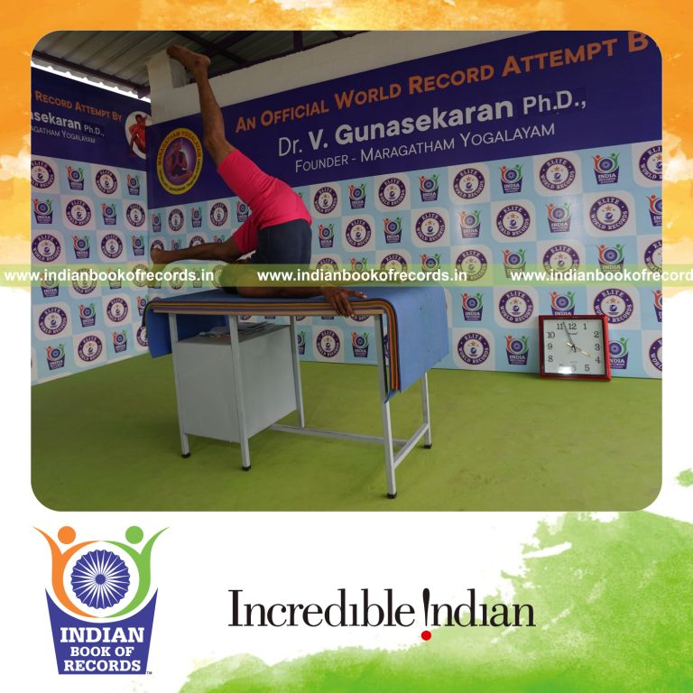 individual holding vama ekapada salamba sarvangasana yoga pose on a table for record in Indian Book of Records
