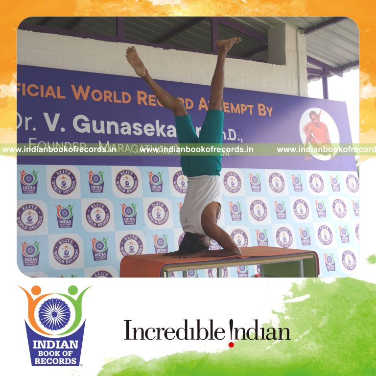 an individual holding vama ekapada salamba sirsasana yoga pose blindfolded on a table continuously for the longest duration with control and balance for a record in Indian Book of Records