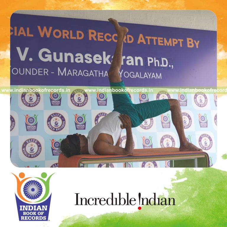 an individual holding vama ekapada setu bandha sarvangasana yoga pose blindfolded on a table continuously for the longest duration with control and balance for a record in Indian Book of Records