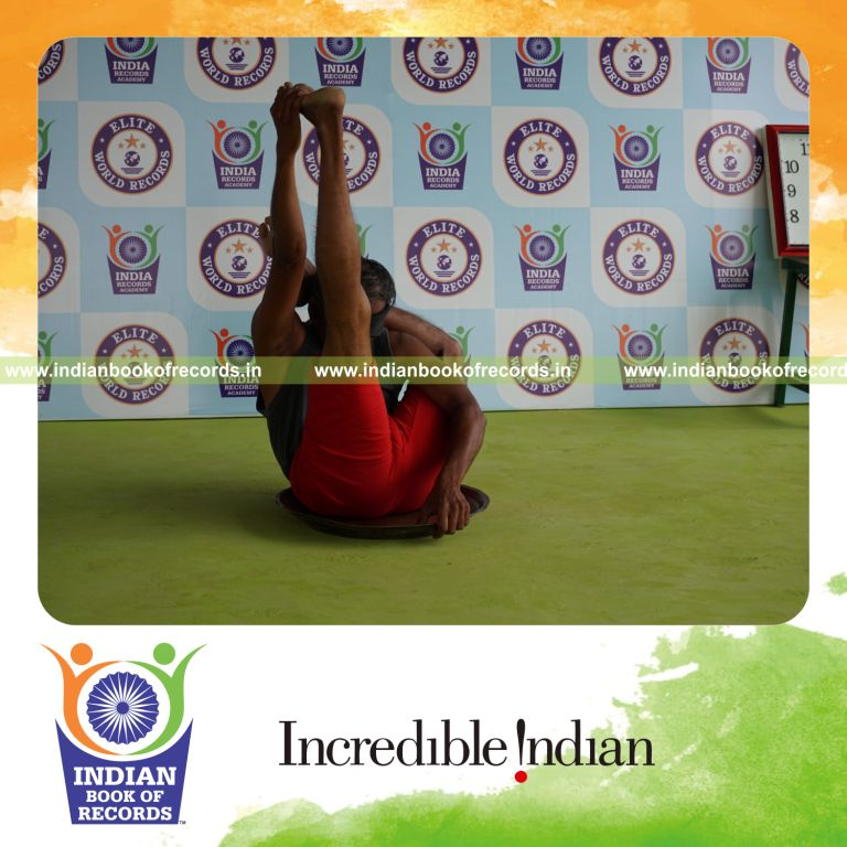 individual holding vama ekapada sirasa krounchasana yoga pose blindfolded on a brass plate for record in Indian Book of Records