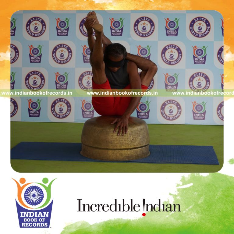 individual holding vama ekapada sirasa krounchasana yoga pose blindfolded on a vessel for record in Indian Book of Records