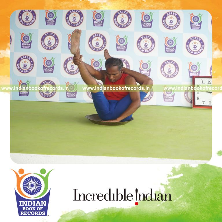 individual holding vama ekapada sirasa krounchasana yoga pose on a brass plate for record in Indian Book of Records