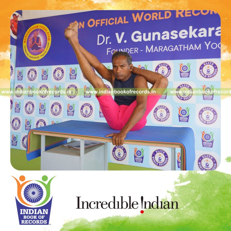 an individual holding vama ekapada sirasa krounchasana yoga pose on a table for the longest duration with control and flexibility for a record in Indian Book of Records