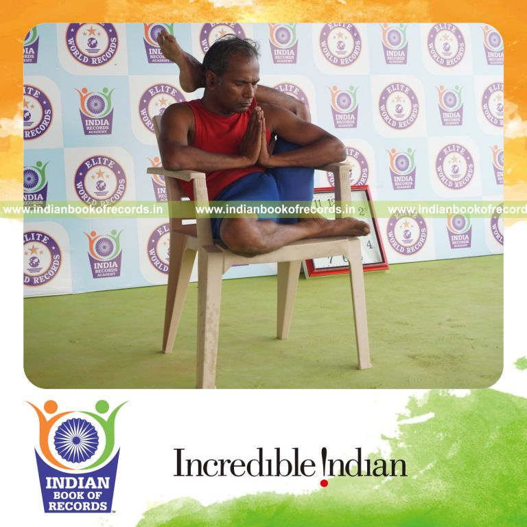 individual holding vama ekapada sirsasana yoga pose on a chair for record in Indian Book of Records