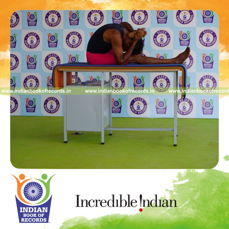 individual holding vama ekapada skandasana yoga pose on a table for record in Indian Book of Records