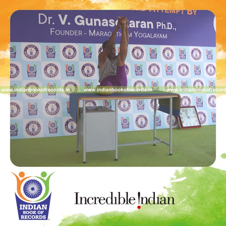 individual holding vama gomukha krounchasana yoga pose on a table for record in Indian Book of Records