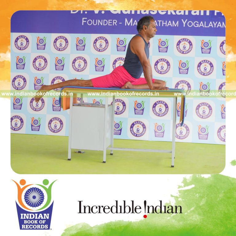 individual holding vama janu bhujangasana yoga pose on a table for record in Indian Book of Records