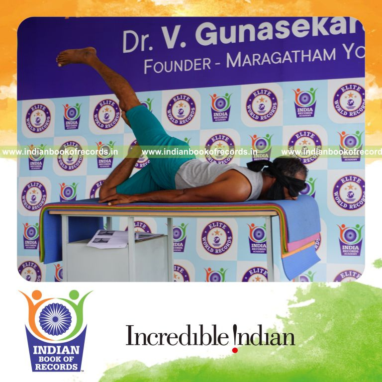 individual holding vama janu salabhasana yoga pose blindfolded on a table for record in Indian Book of Records