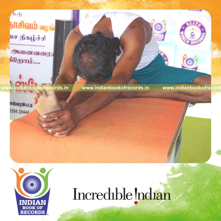 an individual holding vama janu sirsasana yoga pose blindfolded on a table continuously for the longest duration with stability and control for a record in Indian Book of Records