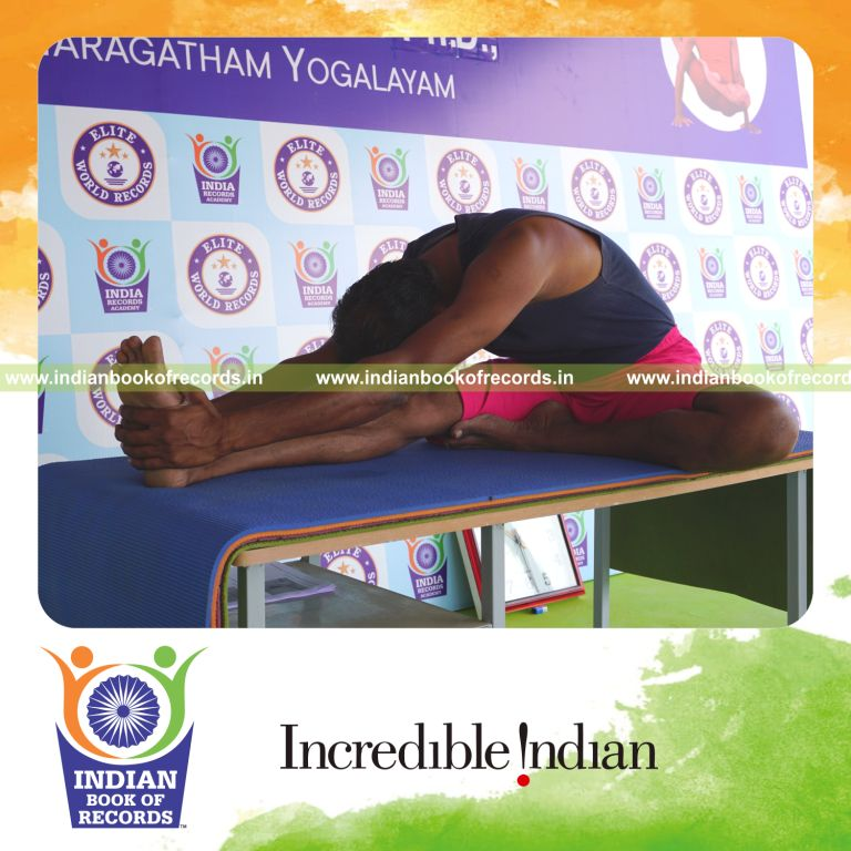 an individual holding vama janu sirsasana yoga pose on a table for the longest duration with flexibility and control for a record in Indian Book of Records