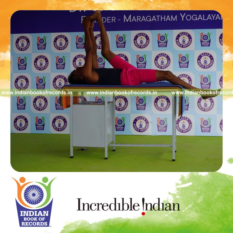 individual holding vama julasana yoga pose on a table for record in Indian Book of Records