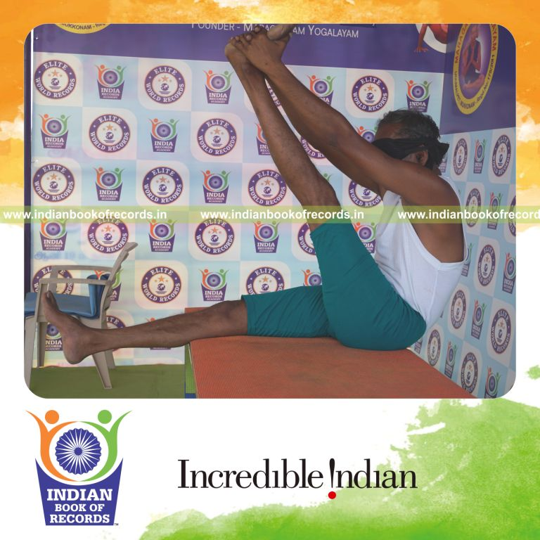 an individual holding vama krounchasana yoga pose blindfolded on a table continuously for the longest duration with stability and control for a record in Indian Book of Records