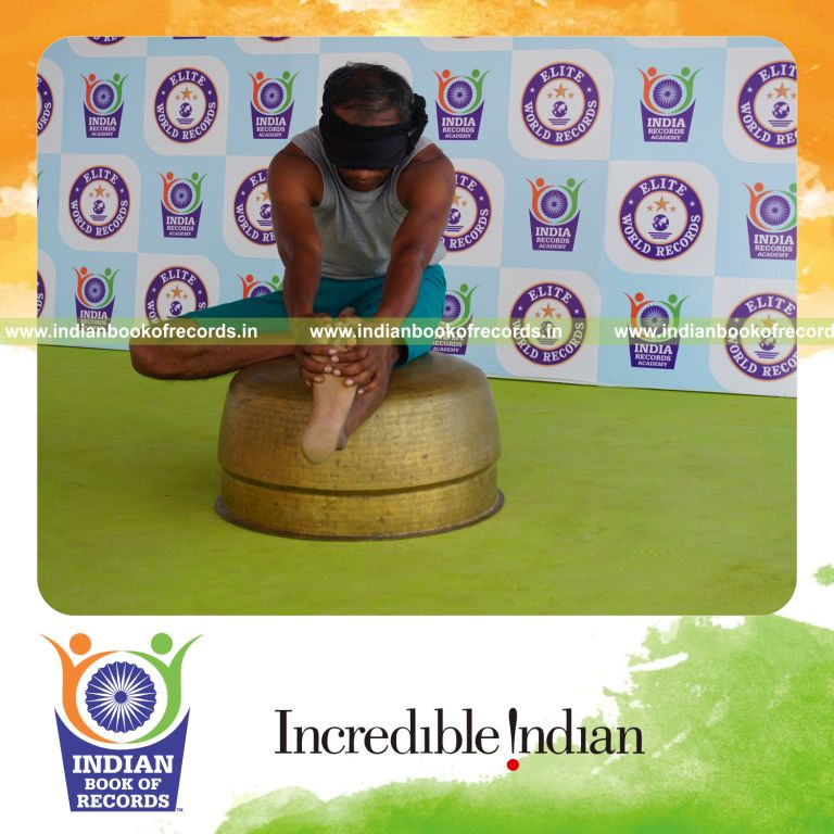 individual holding vama mahamudra yoga pose blindfolded on a vessel for record in Indian Book of Records
