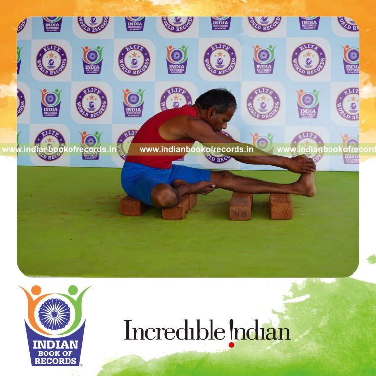 individual holding vama mahamudra yoga pose on bricks for record in Indian Book of Records