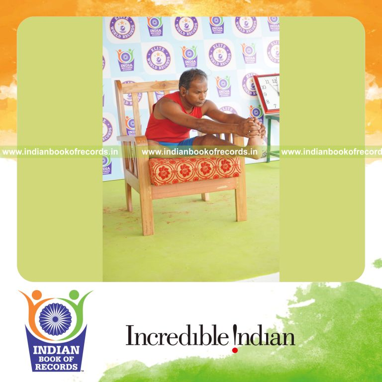 individual holding vama mahamudra yoga pose on a chair for record in Indian Book of Records
