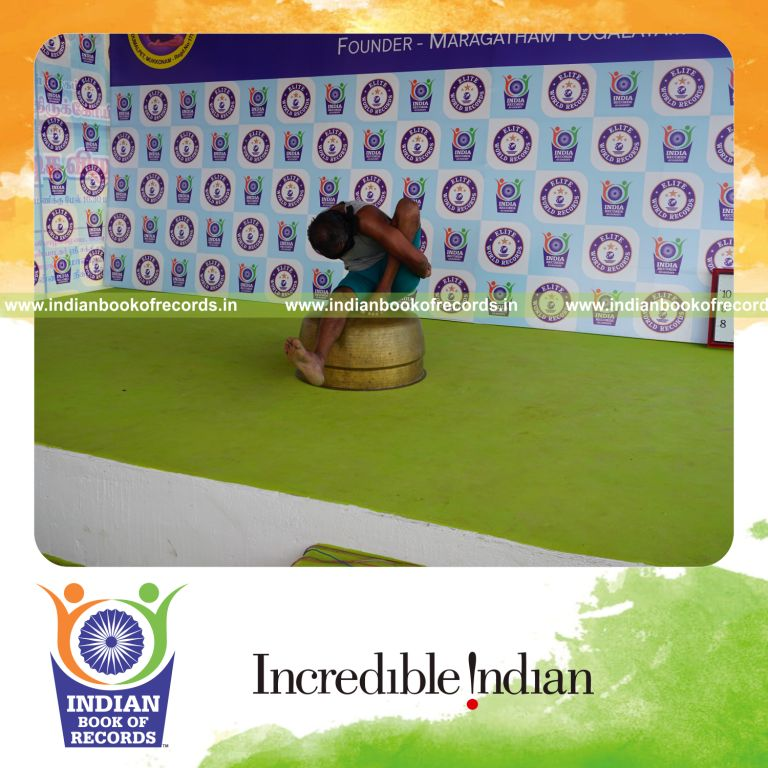individual holding vama marichyasana yoga pose blindfolded on a vessel for record in Indian Book of Records