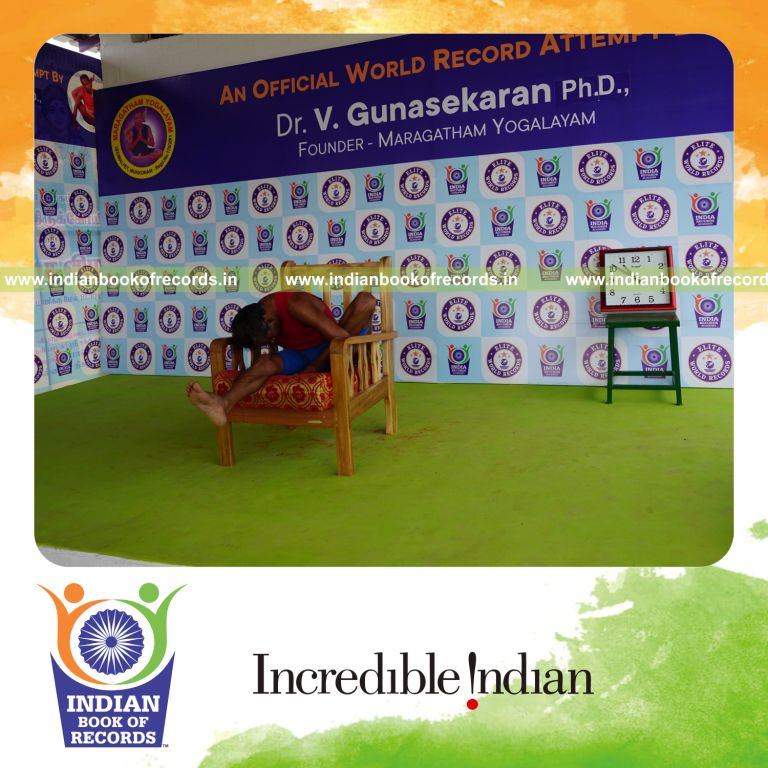 individual holding vama marichyasana yoga pose on a chair for record in Indian Book of Records