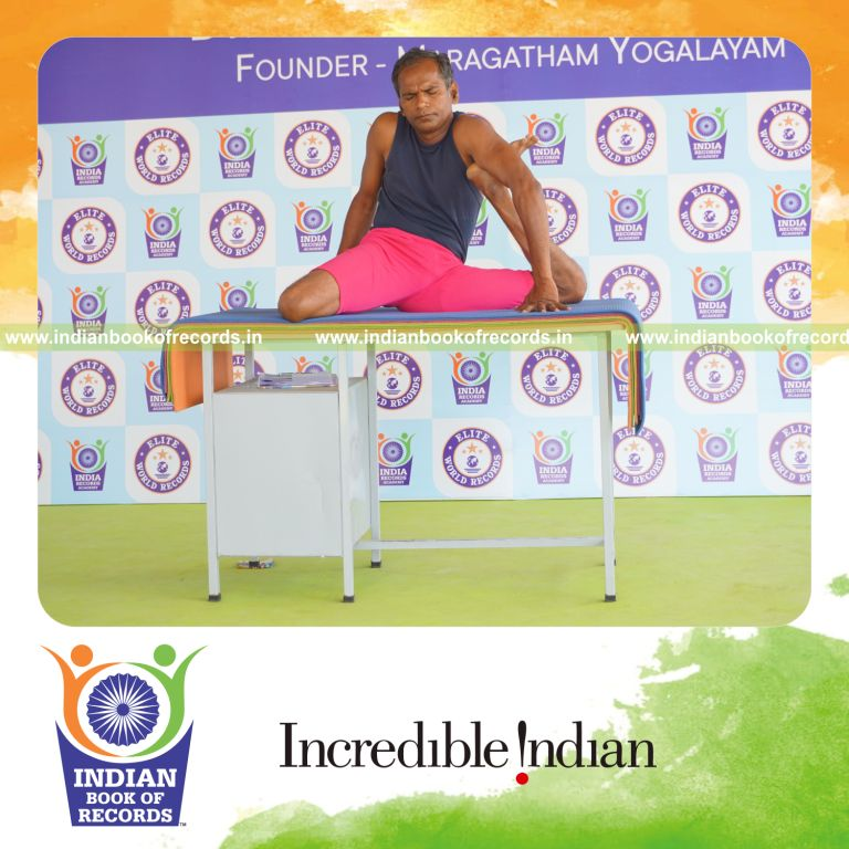 individual holding vama mrigasana yoga pose on a table for record in Indian Book of Records