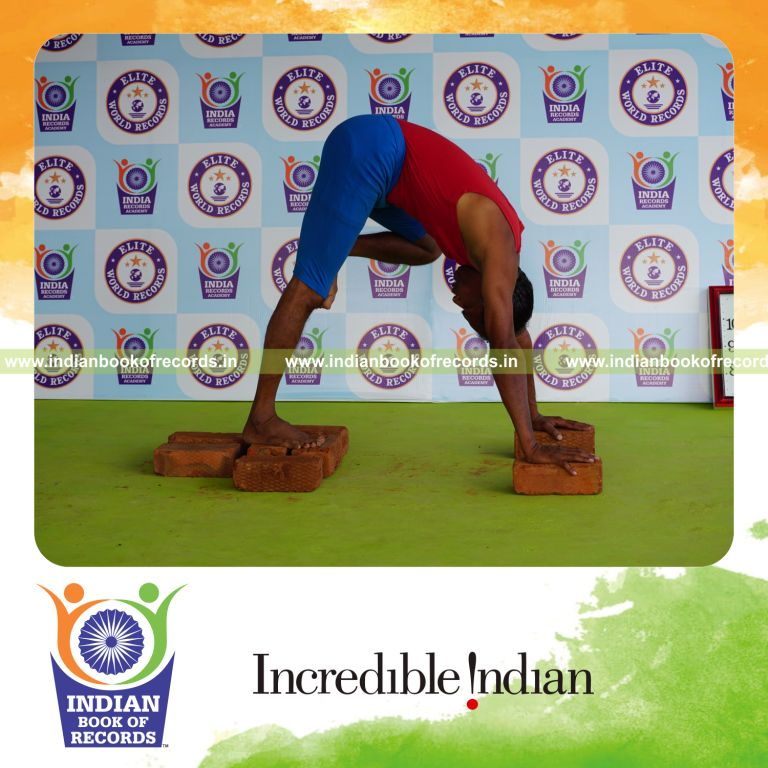 individual holding vama nasika purusta janu parsvasana yoga pose on bricks for record in Indian Book of Records
