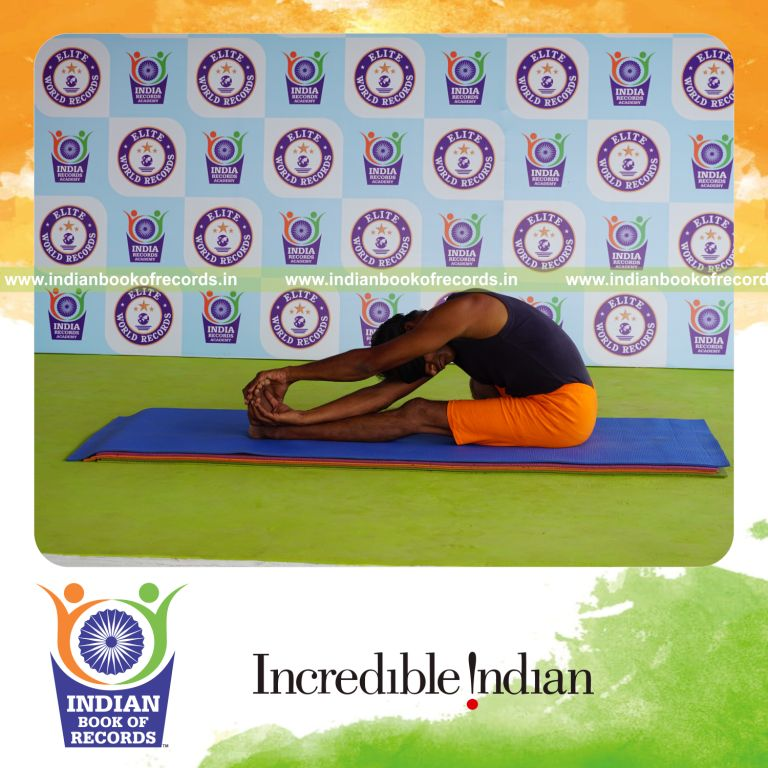individual holding vama parivrtana janu sirsasana yoga pose blindfolded for record in Indian Book of Records