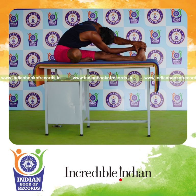 individual holding vama parivrtana janu sirsasana yoga pose on a table for record in Indian Book of Records