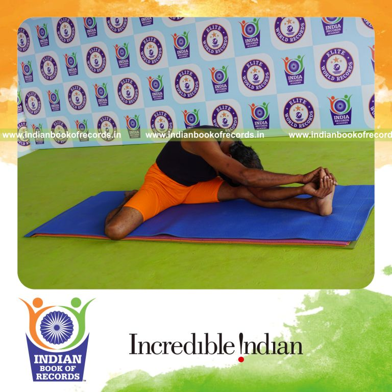 individual holding vama parivrtta gomukha janu sirsasana yoga pose blindfolded for record in Indian Book of Records