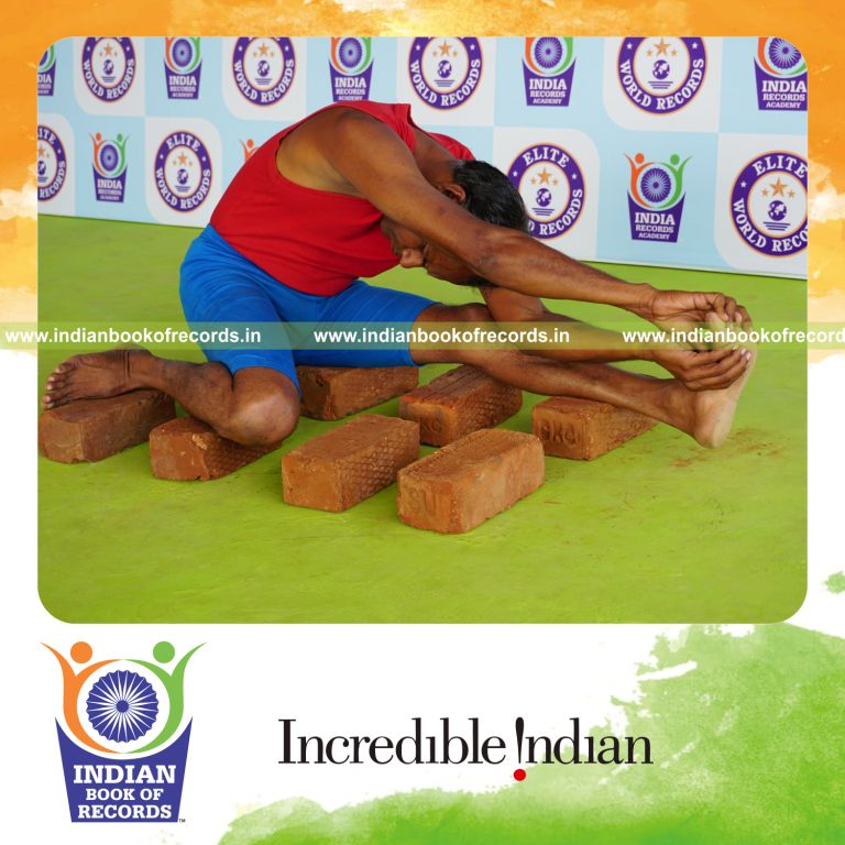 individual holding vama parivrtta gomukha janu sirsasana yoga pose on bricks for record in Indian Book of Records