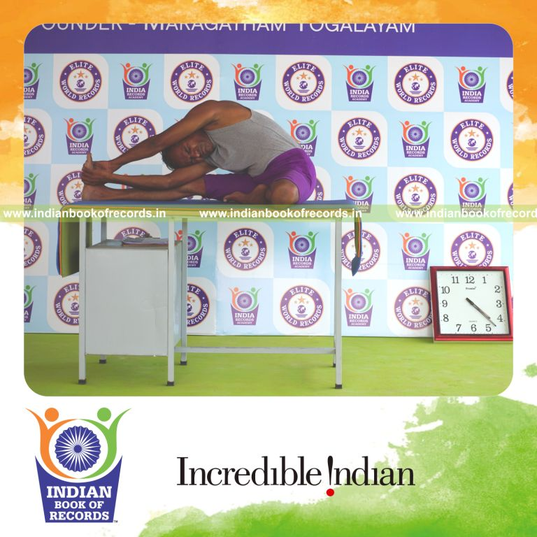 individual holding vama parivrtta janu sirsasana yoga pose on a table for record in Indian Book of Records