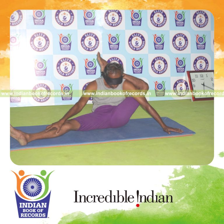 individual holding vama parshwa ekapada sirsasana yoga pose blindfolded for record in Indian Book of Records