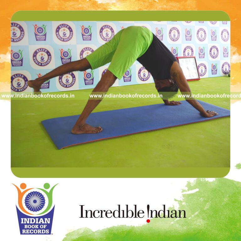 an individual holding vama parsva ekapada adho mukha svanasana yoga pose blindfolded for the longest duration with control and flexibility for a record in Indian Book of Records