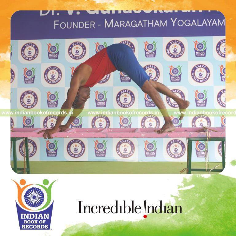 individual holding vama parsva ekapada adho mukha svanasana yoga pose on a ladder for record in Indian Book of Records