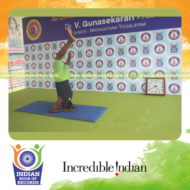 an individual holding vama parsva ekapada salamba sirsasana yoga pose blindfolded for the longest duration with control and balance for a record in Indian Book of Records