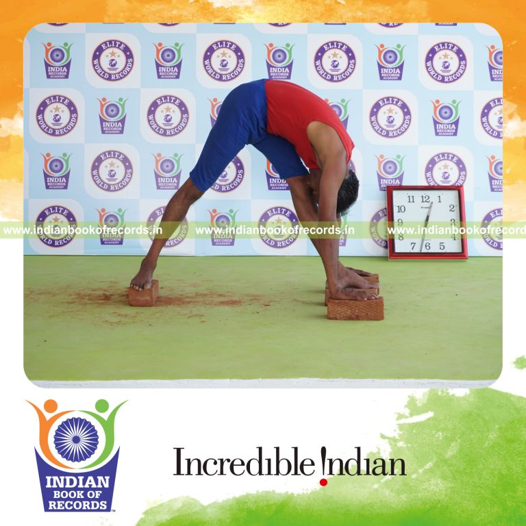 individual holding vama parsvottanasana yoga pose on bricks for record in Indian Book of Records
