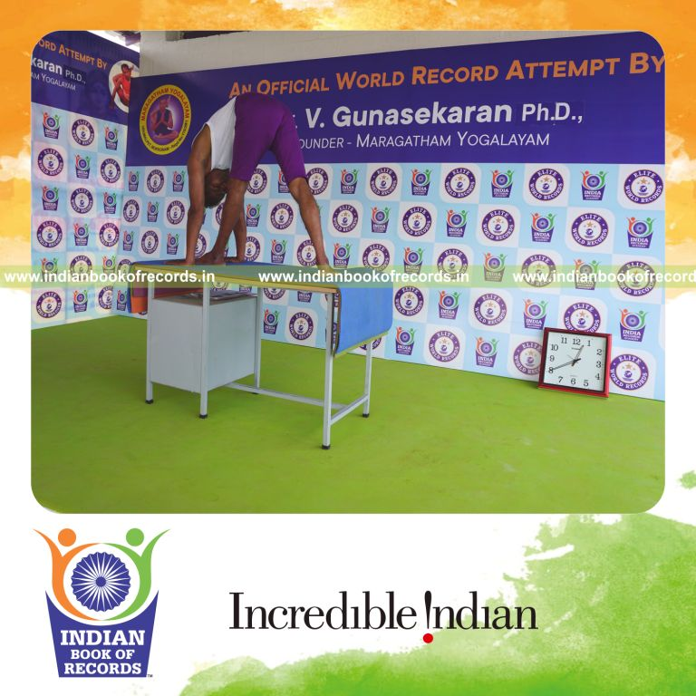 individual holding vama parsvottanasana yoga pose on a table for record in Indian Book of Records